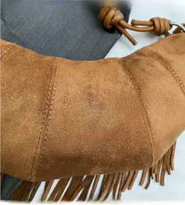 Close-up of retro brown suede crescent bag with fringe tassels and quilted texture