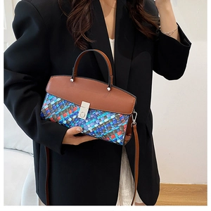 Détail du sac fourre-tout tissé multicolore avec rabat en cuir marron et fermoir métallique