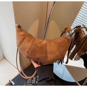 Retro brown suede crescent bag with tassels and knot strap shown from a front angle