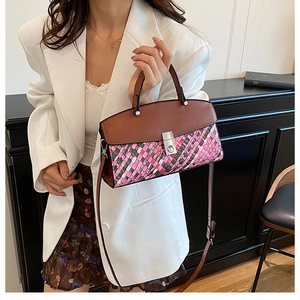 Detail of multi-color woven tote bag with brown leather flap and silver metal buckle