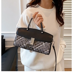 Detailed close-up of woven tote bag with tricolor pattern and silver metal buckle lock