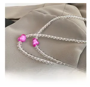 Detail of beaded shoulder strap with clear round beads and pink heart ornaments