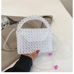 Detail of hand-woven transparent beaded bag with pink heart charms and crystal texture