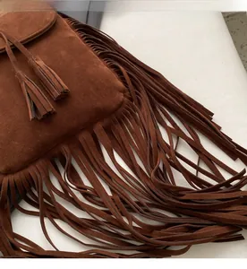 Détail d'un sac en daim marron avec de longues franges et fermeture à cordon