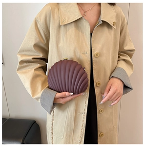 Deep burgundy shell clutch with radial texture, gold ball clasp, and chain strap detail