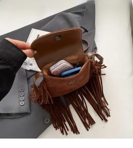 Détail de l'intérieur du sac en daim avec poche zippée et longues franges rétro