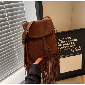 Détail d'un sac bandoulière en daim marron mat avec de longues franges et sangle réglable
