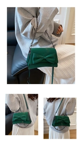 Dettaglio della borsa a tracolla verde scuro con grande fiocco decorativo e catena