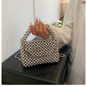 Detail of silver beaded acrylic woven bag featuring metallic reflective facets