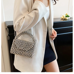 Detail of silver beaded crossbody bag featuring metallic luster and chain strap