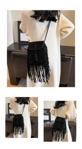 Detail van zwarte suède crossbodytas met lange franjes en bohemian ontwerp