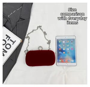 Size comparison of burgundy velvet evening bag with silver chain and rhinestone ring buckle