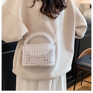 Close-up of a woven acrylic bead crossbody bag with a transparent flap and top handle