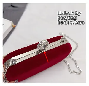Close-up of red velvet evening bag with silver diamond ring buckle and metal chain detail