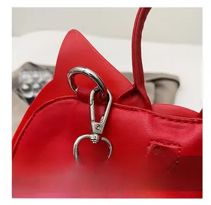 Gros plan du crochet en métal argenté et du zip sur le sac chauve-souris en cuir rouge