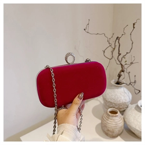 Macro detail of magenta velvet evening bag with rhinestone ring clasp and silver chain