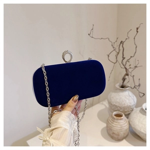 Close-up of velvet evening bag featuring a rhinestone-encrusted silver ring clasp and chain