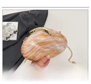 Close-up of orange marble acrylic evening bag with gold chain and metal clasp