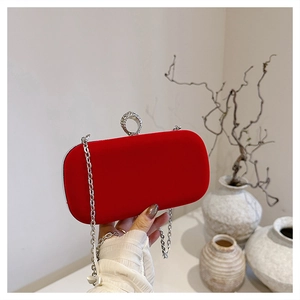 Detailed shot of red velvet evening clutch with silver rhinestone ring clasp and metal chain