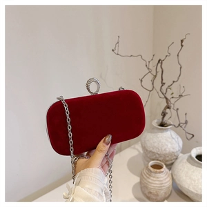 Close-up of velvet evening bag with rhinestone ring clasp and silver chain strap