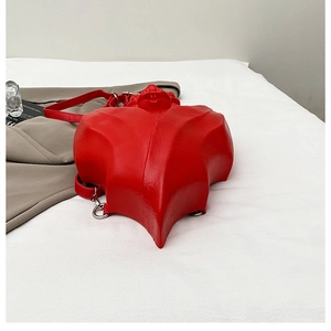 Détail du sac à main rouge avec gaufrage 3D rose, crochets métalliques et sangles