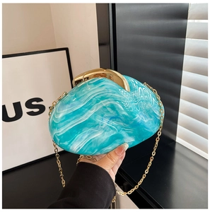 Detail view of turquoise marble acrylic evening bag with gold metal clasp and chain strap