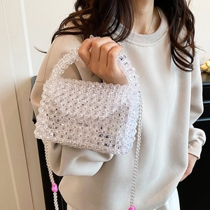 Chic acrylic beaded handbag with pink charms shown on a model from a 45-degree angle