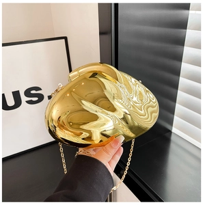 Detailed close-up of a high-polish gold wavy acrylic evening clutch bag with chain strap
