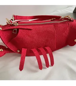Detailed macro shot of red suede lobster bag material and premium gold metal zipper