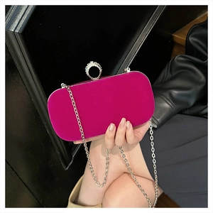 Detail of fuchsia velvet clutch featuring a crystal-embellished silver ring clasp