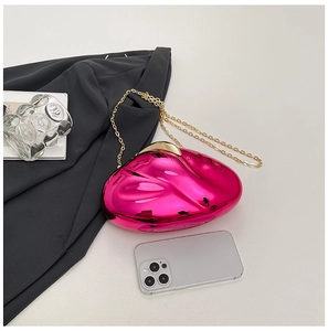 Magenta acrylic clutch bag with metallic finish and gold chain strap on flat lay surface