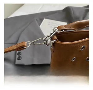 Détails des crochets métalliques argentés sur un sac seau en daim marron