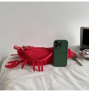 Detailed macro shot of the matte red lobster crossbody bag showing premium suede texture