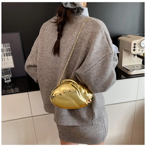 Close-up of golden metallic heart-shaped clutch bag with elegant chain shoulder strap