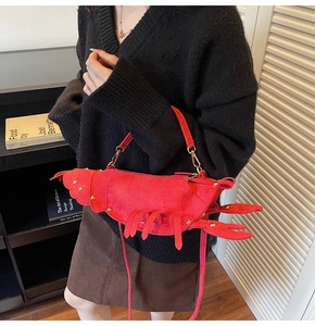 Detailed view of red lobster shaped crossbody bag with gold hardware on a model