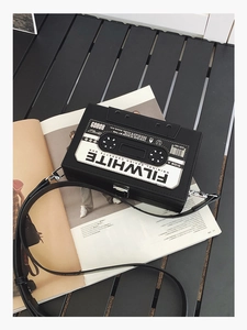 Detalle del bolso bandolera retro con forma de cassette y correa ajustable de color negro