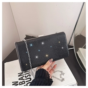 Close-up of black evening clutch with glittering rhinestones and silver chain strap