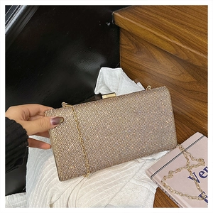 Close-up of champagne gold evening clutch with sparkling rhinestones and chain