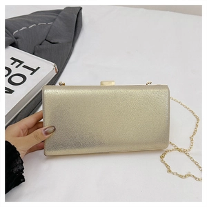 Detailed macro view of a gold hard shell evening bag with a metallic glitter finish