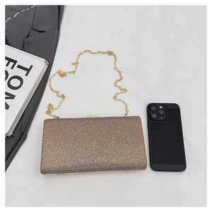 Close-up of gold rhinestone clutch bag with chain strap and smartphone for size comparison