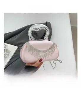 Detail of pink satin evening bag with rhinestone fringe and silver metal handle