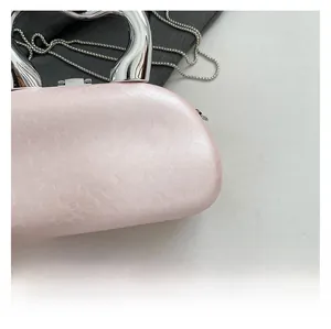 Detail of pink acrylic evening bag with pearlescent texture and silver metal handle