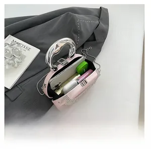 Pink acrylic evening bag with rhinestone tassels showing interior storage capacity