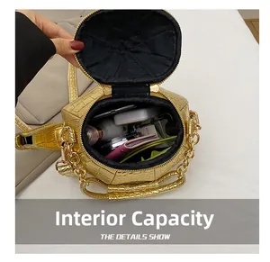 Internal capacity of gold crocodile pattern handbag showing phone and cosmetics storage