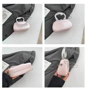 Detail of pink pearlescent evening bag with heart handle and rhinestone tassels