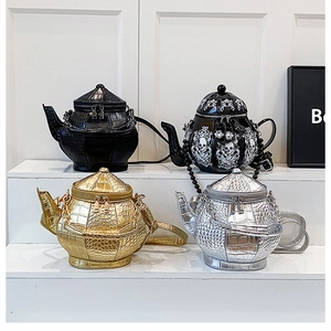 Detail of creative teapot bags in black, gold, and silver finishes with crocodile texture