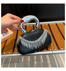 Detail of acrylic evening bag with silver metal handle and rhinestone fringe tassels