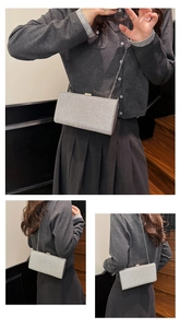 Detail of silver sequin evening clutch bag with fine metal chain and structured box design