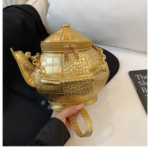 Macro shot of 3D teapot bag showing golden crocodile pattern and dual zip detail