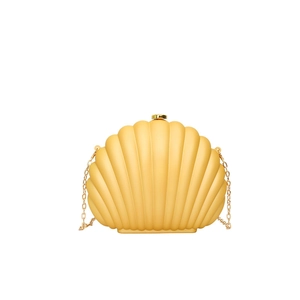 Detailed view of yellow shell clutch bag with gold chain strap and textured scallop pattern